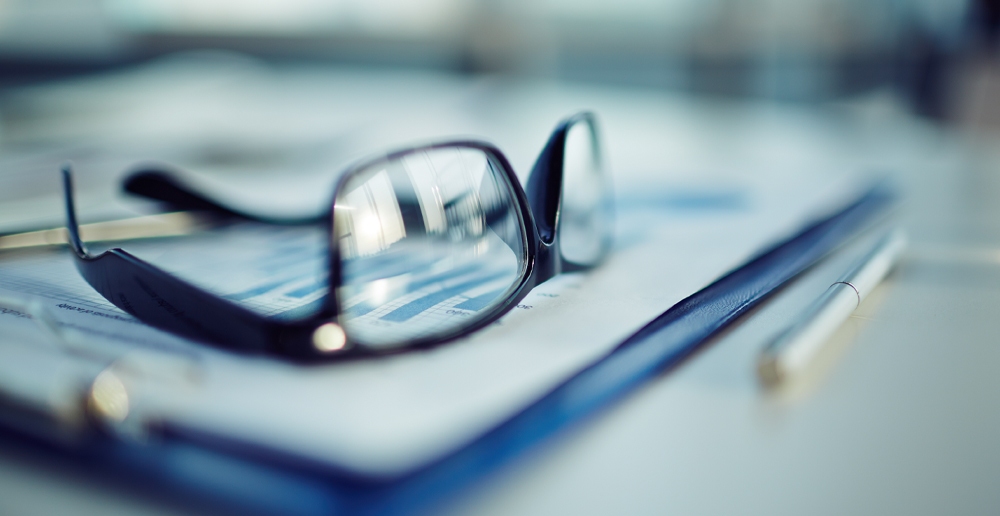 Presse-papiers avec document, stylo et lunettes