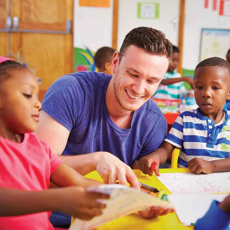 Un éducateur dirige un atelier de dessin avec des enfants.