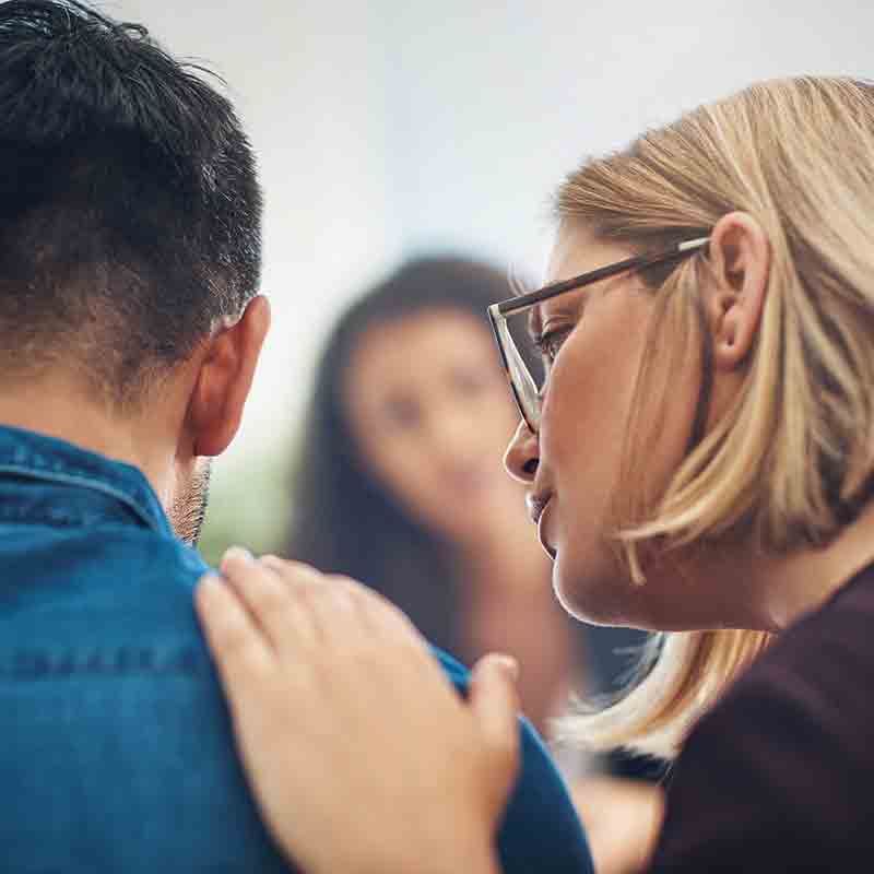 Une femme prend la parole lors d'une consultation avec trois autres personnes.